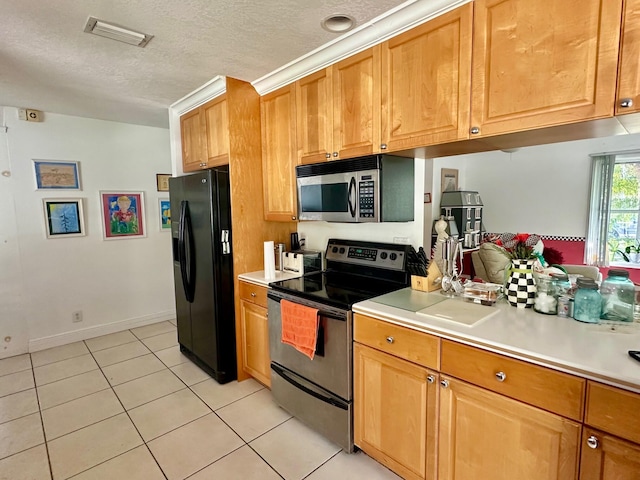 kitchen with a textured ceiling, light tile patterned floors, visible vents, light countertops, and appliances with stainless steel finishes