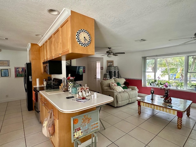 kitchen with light countertops, visible vents, open floor plan, ceiling fan, and black appliances