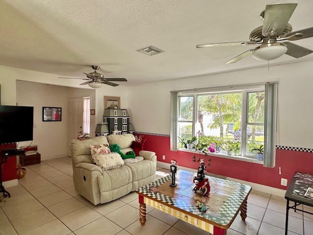 tiled living room featuring ceiling fan and a textured ceiling