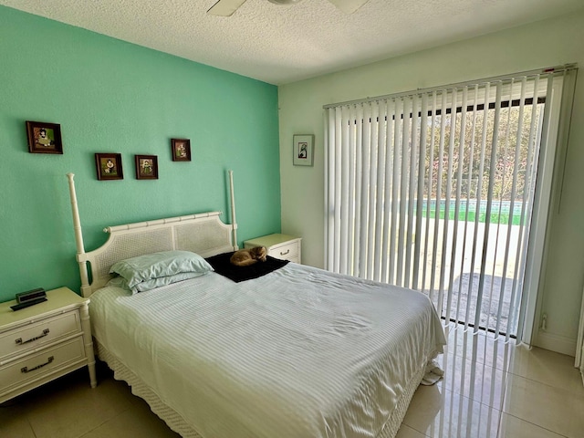 tiled bedroom with access to exterior, multiple windows, and a textured ceiling