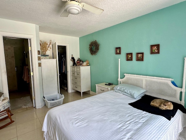 tiled bedroom featuring ceiling fan and a textured ceiling