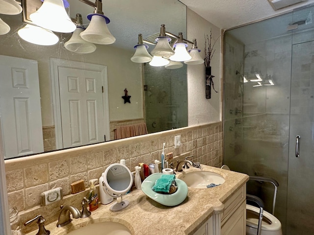 bathroom featuring vanity, tile walls, an enclosed shower, and a textured ceiling