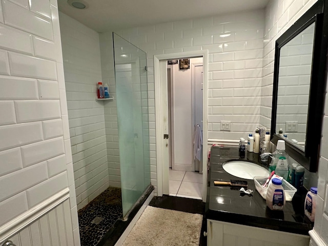 bathroom with tile patterned flooring, a shower stall, and vanity