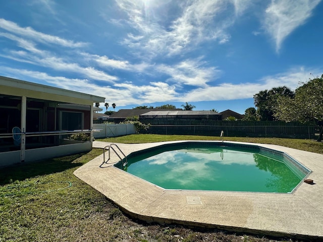 view of pool with a yard and a sunroom