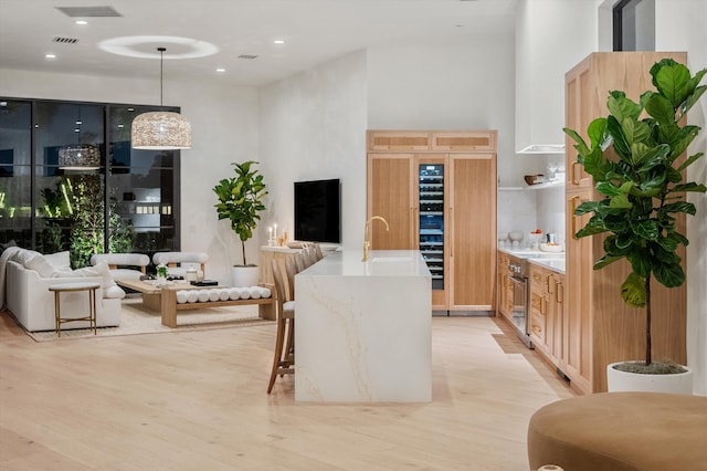 2578 Players Ct, Wellington, FL 33414 - kitchen with sink, decorative light fixtures, light hardwood / wood-style floors, and a towering ceiling