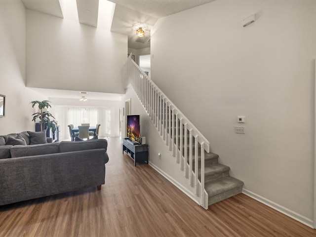 living room with hardwood / wood-style flooring and a towering ceiling