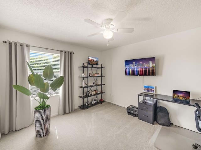 home office featuring ceiling fan, carpet flooring, and a textured ceiling