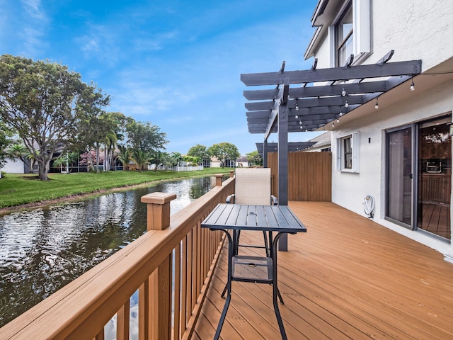 deck featuring a pergola, a lawn, and a water view