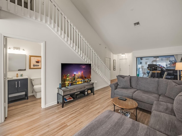 living room featuring a high ceiling and light wood-type flooring