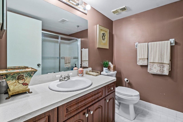 bathroom featuring tile patterned flooring, vanity, a shower with shower door, and toilet