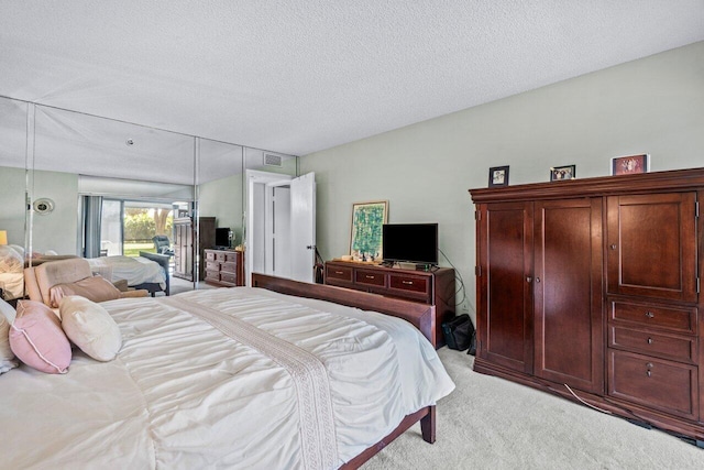 carpeted bedroom with a textured ceiling and access to outside