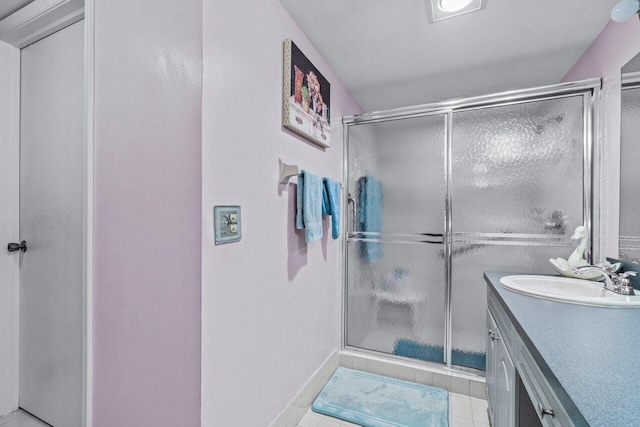 bathroom featuring tile patterned floors, vanity, and a shower with shower door