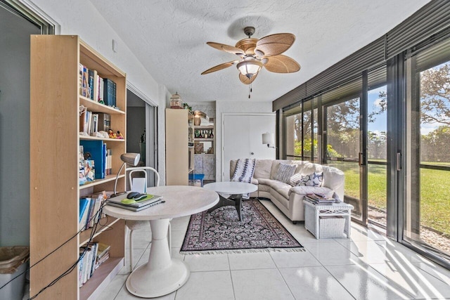 living room with ceiling fan, a wealth of natural light, a textured ceiling, and light tile patterned flooring