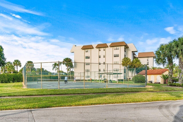 view of tennis court featuring a yard