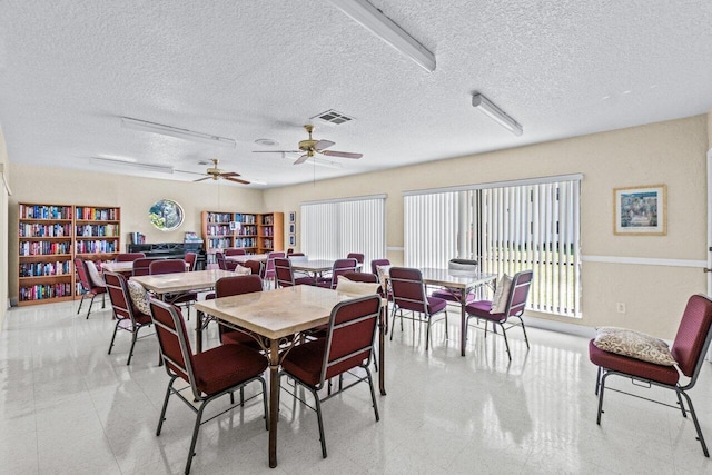 dining area with ceiling fan and a textured ceiling