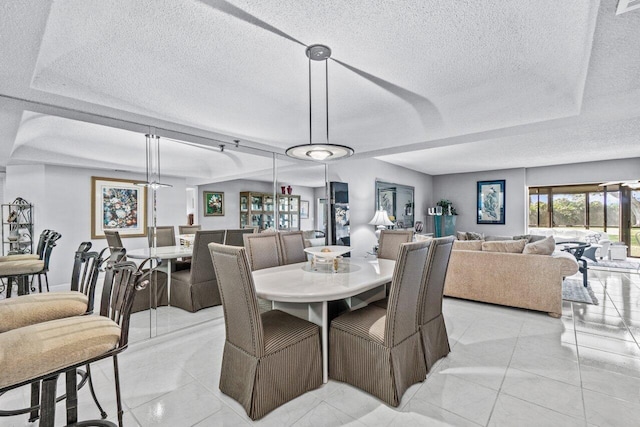 dining area with light tile patterned floors and a textured ceiling