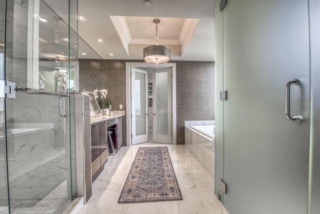 bathroom featuring vanity, separate shower and tub, crown molding, and a tray ceiling