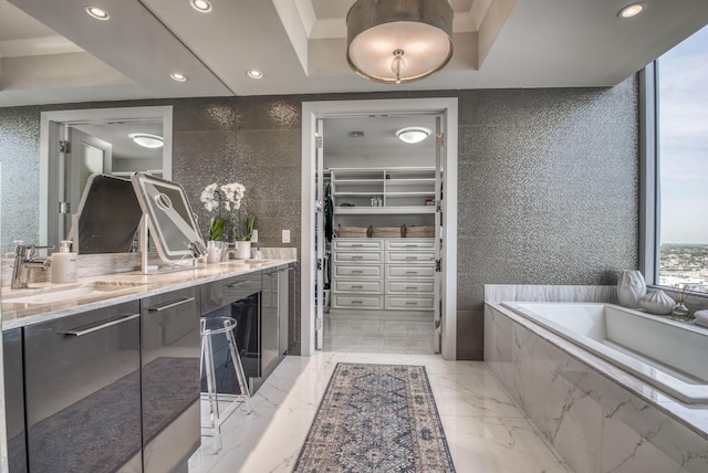 bathroom featuring vanity, tile walls, and tiled bath