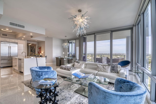 living room featuring sink, a chandelier, and a wall of windows