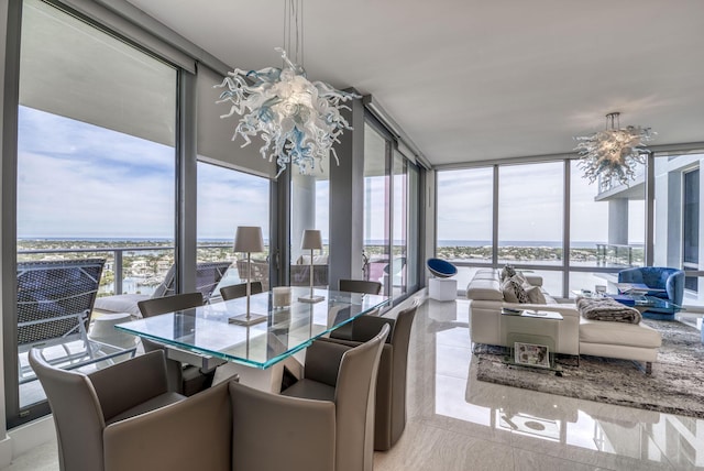 sunroom featuring an inviting chandelier and a water view