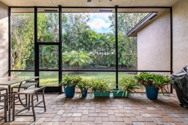 sunroom / solarium with a healthy amount of sunlight and ceiling fan