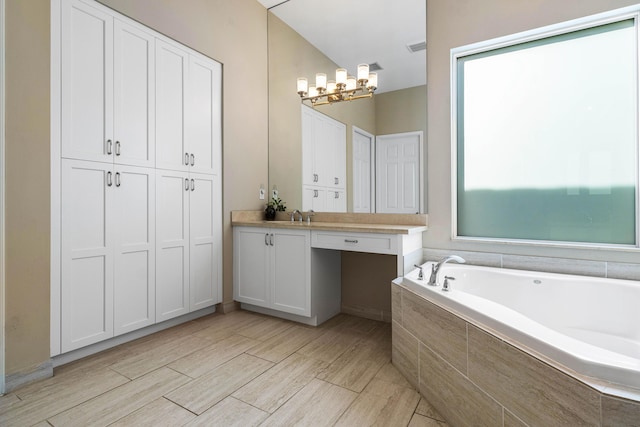 bathroom featuring a relaxing tiled tub, vanity, a chandelier, and wood-type flooring