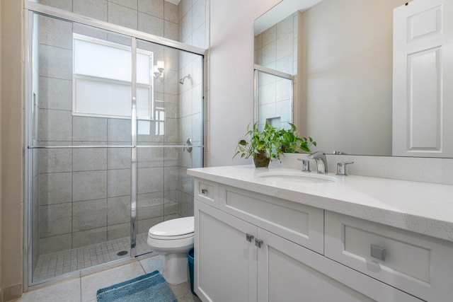 bathroom featuring vanity, toilet, an enclosed shower, and tile patterned flooring