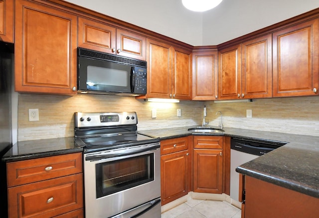 kitchen with stainless steel appliances, sink, dark stone countertops, and backsplash