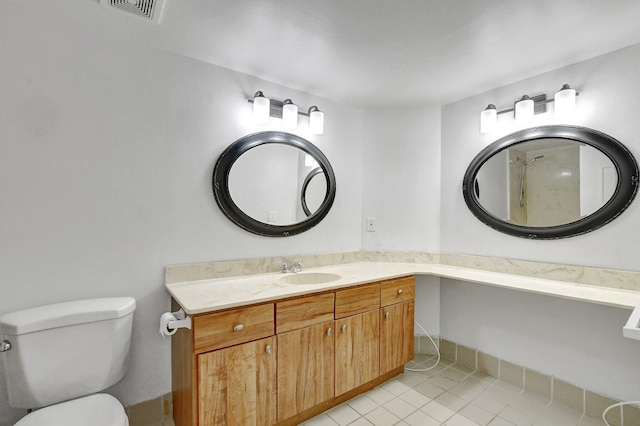 bathroom with toilet, tile patterned flooring, visible vents, and vanity