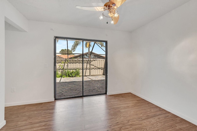 unfurnished room featuring a ceiling fan, baseboards, and wood finished floors