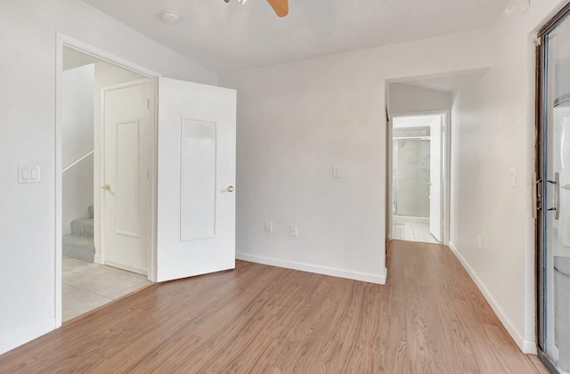 unfurnished bedroom with ceiling fan, light wood finished floors, ensuite bath, and baseboards