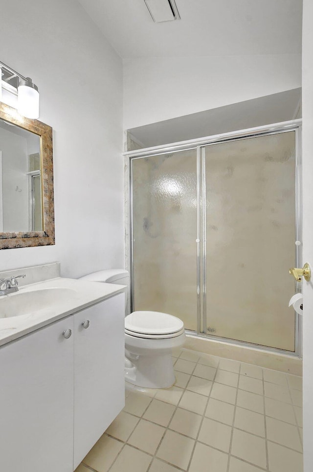 bathroom featuring toilet, vaulted ceiling, a shower stall, vanity, and tile patterned floors