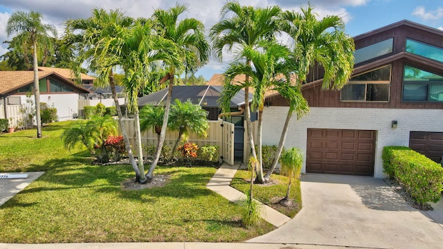 view of front of home featuring a garage, a lanai, and a front lawn