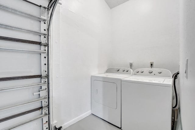 washroom with laundry area, independent washer and dryer, and baseboards