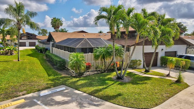 exterior space featuring driveway, glass enclosure, a front lawn, and brick siding