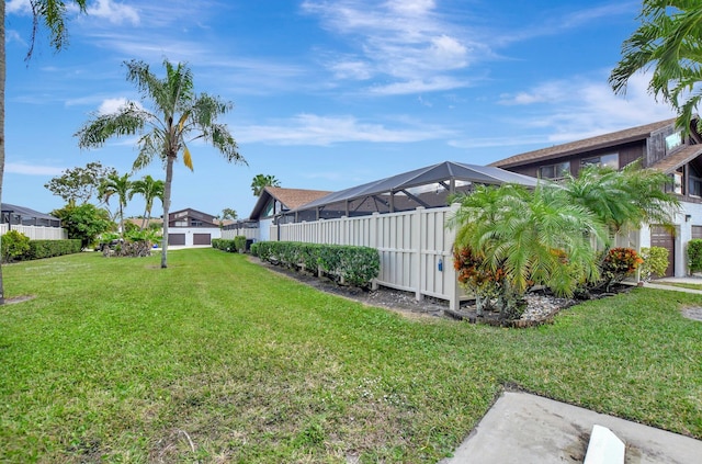 view of yard with glass enclosure and fence