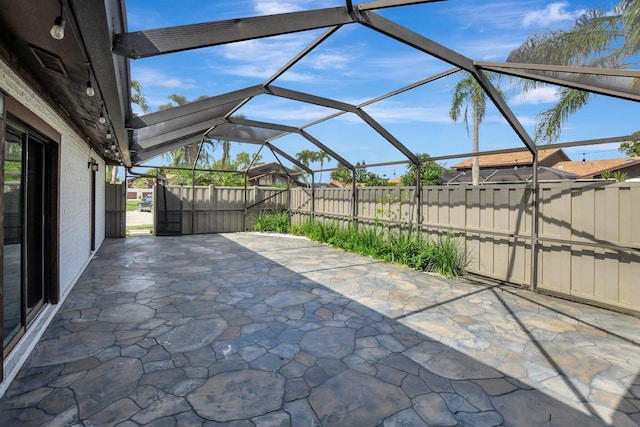 view of patio / terrace featuring glass enclosure and a fenced backyard