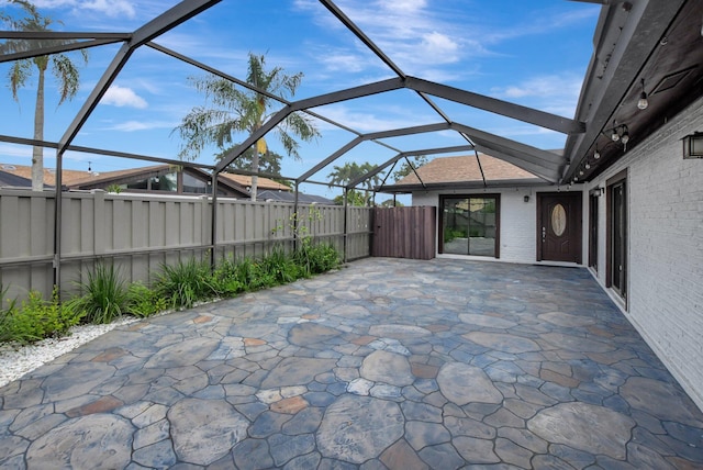 view of patio / terrace featuring glass enclosure and a fenced backyard