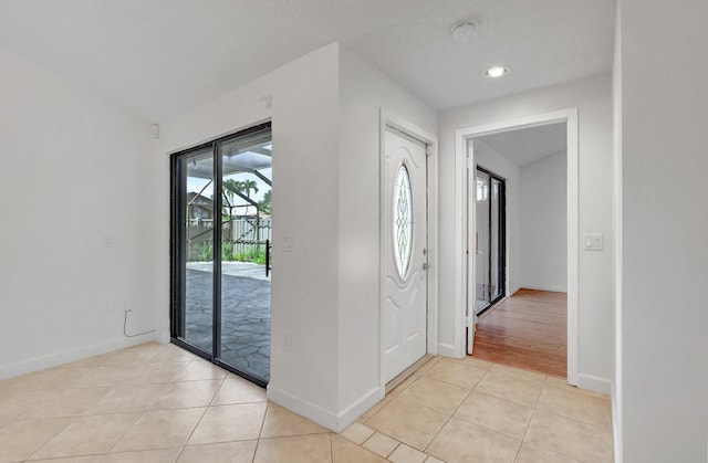 entryway with light tile patterned floors and baseboards