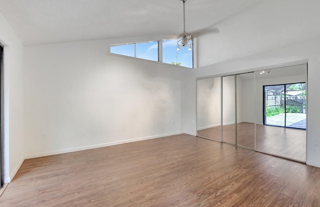 unfurnished bedroom with access to exterior, a closet, ceiling fan, wood finished floors, and baseboards