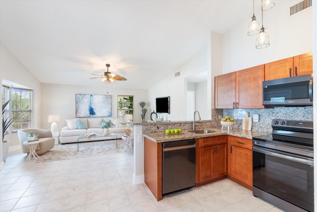 kitchen with light stone counters, stainless steel appliances, sink, and plenty of natural light