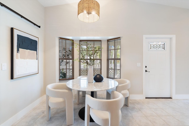 tiled dining space with a barn door, a healthy amount of sunlight, and a notable chandelier