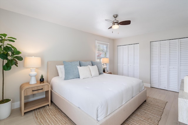 bedroom with ceiling fan, multiple closets, and light wood-type flooring