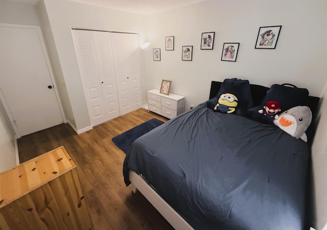 bedroom with dark hardwood / wood-style flooring, a textured ceiling, and a closet