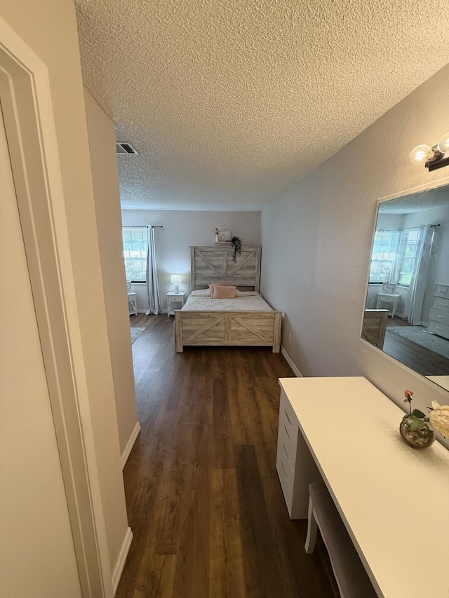 unfurnished bedroom featuring dark wood-type flooring and a textured ceiling