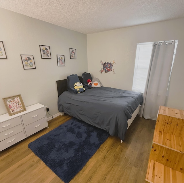 bedroom featuring dark hardwood / wood-style flooring and a textured ceiling