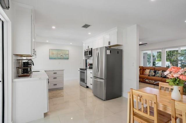 4448 SW 34th Ter, Dania Beach, FL 33312 - kitchen with appliances with stainless steel finishes, white cabinetry, recessed lighting, a sink, and light stone countertops