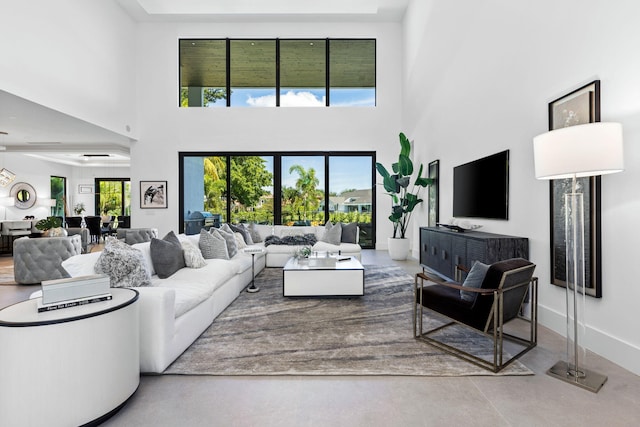 living room featuring a towering ceiling and concrete floors