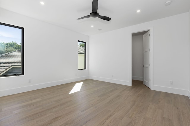 spare room with ceiling fan, light hardwood / wood-style floors, and a healthy amount of sunlight