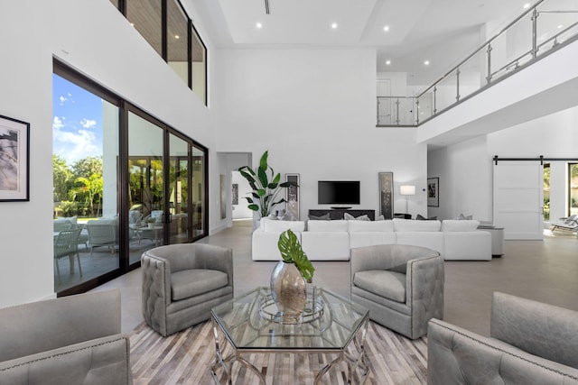 living room with a barn door and a high ceiling